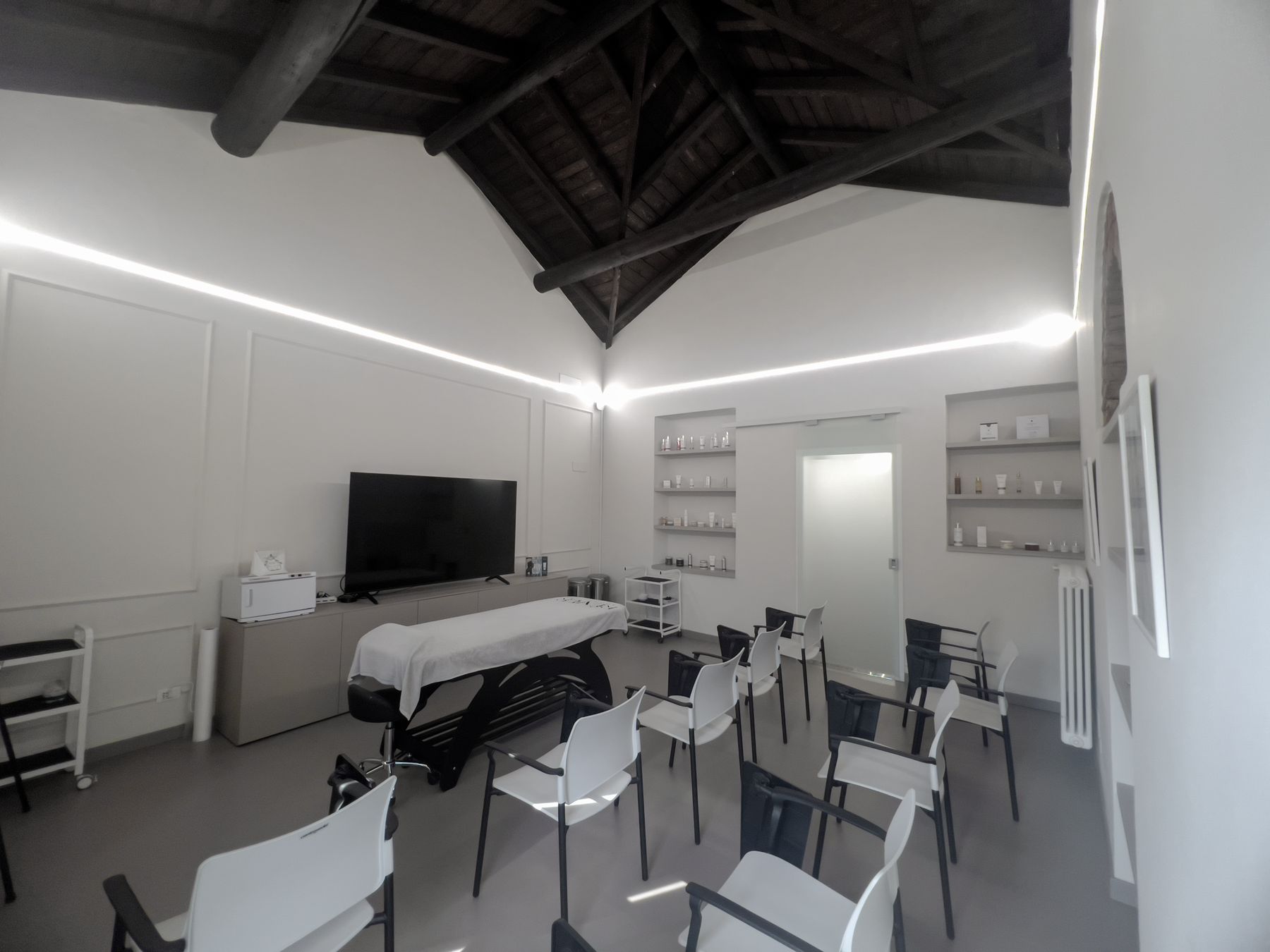 Sala bianca dell'Académie con maxischermo, lettino e sedute